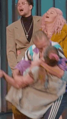 a man wearing a cross necklace is carrying a woman in his arms