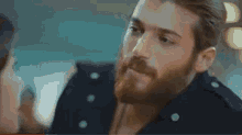 a man with a beard is kissing a woman on the forehead .