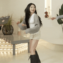 a woman in a gray sweater and shorts is dancing