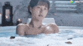 a naked woman is taking a bath in a hot tub