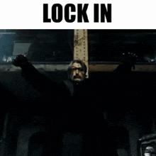 a man with his arms outstretched in a dark room with the words lock in above him