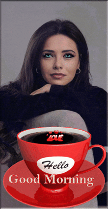 a woman sits next to a cup of coffee that says hello good morning on it