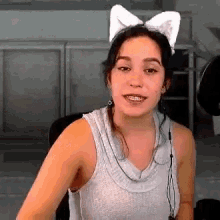 a woman wearing a cat ear headband is sitting in a chair .