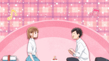 a boy and a girl are sitting on a pink surface