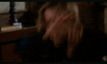 a woman in a white shirt is sitting in a chair with her head in the air .