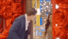 a man in a suit is standing in front of a woman in a dress .