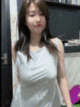 a woman in a white dress is standing in front of a door with her breasts visible .