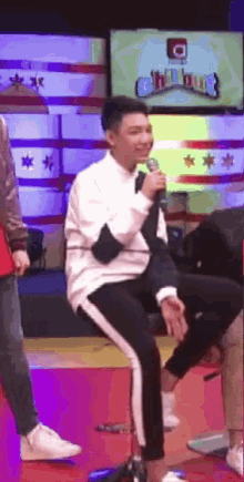 a man sitting on a stool with a microphone in front of a chicago flag