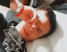 a person laying on a bed with their hand on their face
