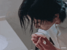 a close up of a person applying nail polish in a bathroom .