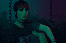 a woman is smoking a cigarette in a dark room with green lights