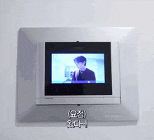 a commax monitor shows a man in a black shirt on the screen