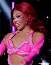 a woman with red hair wearing a pink top and gloves