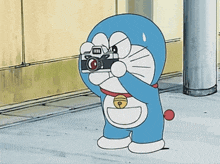 a cartoon of doraemon taking a picture with a camera with the word fuji on it