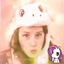 a woman wearing a unicorn hat with a picture of a unicorn on the bottom
