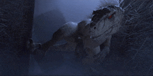 a dinosaur with red eyes is laying down in a dark room