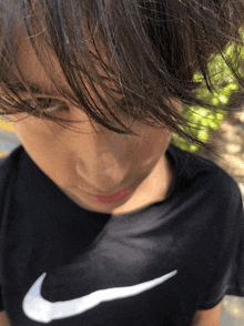 a close up of a person wearing a black nike t-shirt