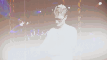 a man wearing sunglasses and a white shirt is dancing