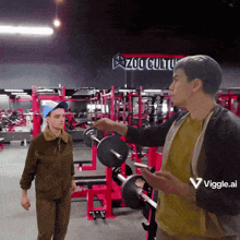 two men are standing in a gym with a sign that says zoo culture