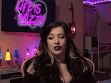 a woman sitting in front of a life is mizzy tv