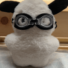 a stuffed animal wearing a pair of goggles with the letter o on them