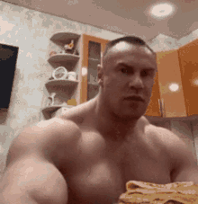 a shirtless man is holding a piece of food in his hand