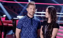 a man and a woman are standing next to each other and smiling .