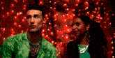 a man in a green shirt is standing next to a woman in a green top