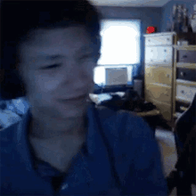 a man wearing headphones is crying while sitting in front of a computer .