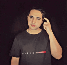 a man wearing a black t-shirt that says paris on it