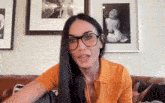 a woman wearing glasses sitting on a couch