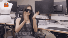 a woman wearing sunglasses is sitting in front of a chilanda monitor