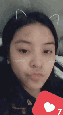a close up of a girl 's face with a heart and the number 1 on it