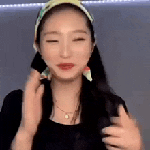 a woman wearing a head scarf and a necklace is making a face .