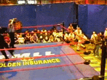 a wrestling ring with a sign that says " golden insurance "