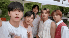 a group of young men are standing next to each other in front of a tent .
