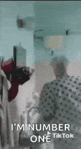 an elderly woman in a hospital gown is standing in front of a mirror .
