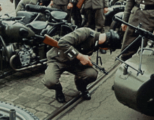 a soldier with the letter h on his arm is kneeling down