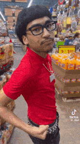 a man wearing glasses and a red shirt is standing in a store