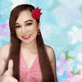 a woman giving a thumbs up with a flower in her hair