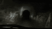 a person is walking through a dark tunnel with a light coming out of the end .