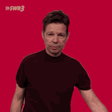 a man making a funny face in front of a red background with swr3 written on it