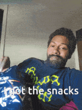 a man holding a bag of doritos with the words i got the snacks written below him