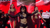 a group of women are dancing on a stage with a sign that says fatal influence on it .