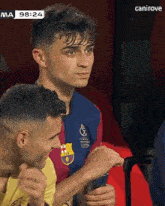 a man in a barcelona shirt is looking at a cell phone