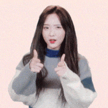a woman in a striped sweater is giving a thumbs up