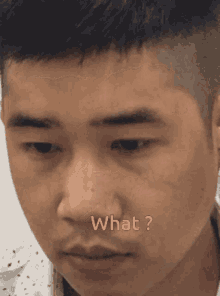 a close up of a man 's face with the words " what " written in pink