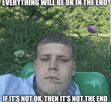 a man sits in a green chair with a caption that says everything will be ok in the end