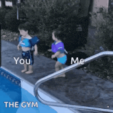 a boy and a girl are standing on the edge of a swimming pool talking to each other .