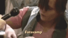a woman is talking into a microphone and the word fotsvamp is on the bottom of the image